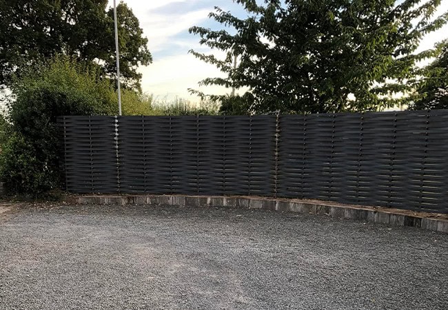 Black metal woven fence completed around gravel