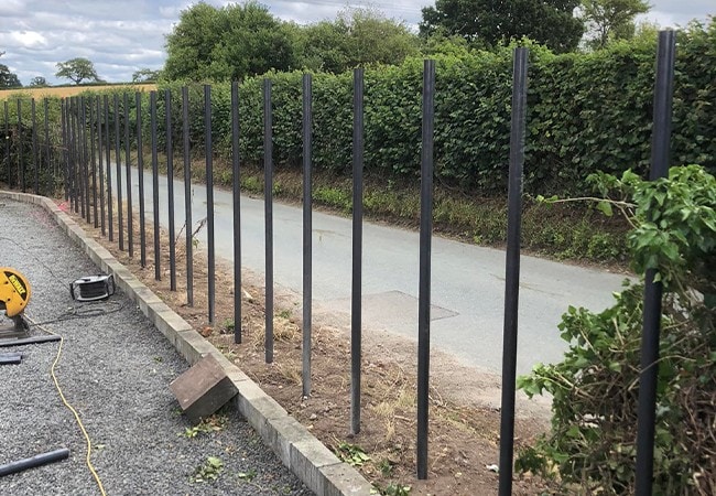 Poles to start woven process by road.