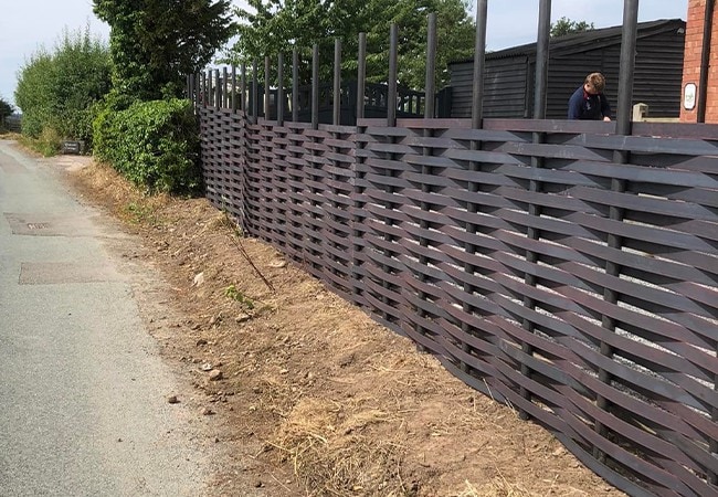 Woven metal fence mostly complete