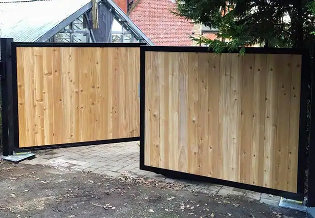 Wooden gate with black metal outline in front of house