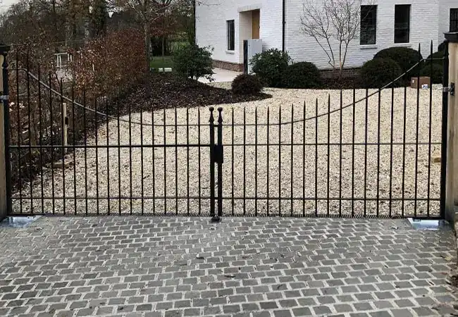 Short black metal fence on driveway
