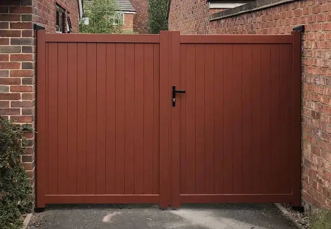 Medium size brown wooden fence between taller brick walls.