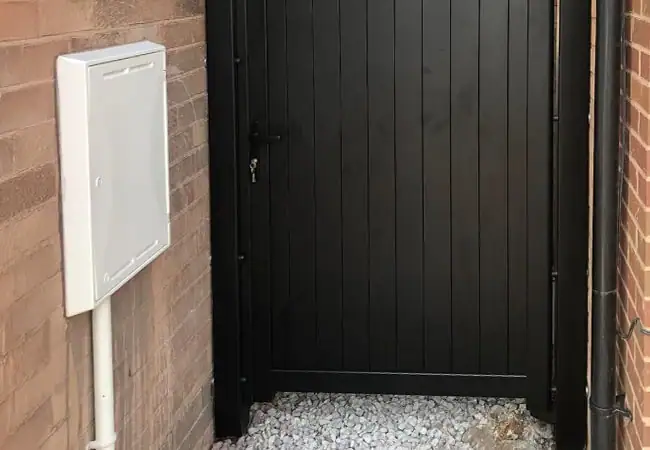 Black wooden door on the side of a house