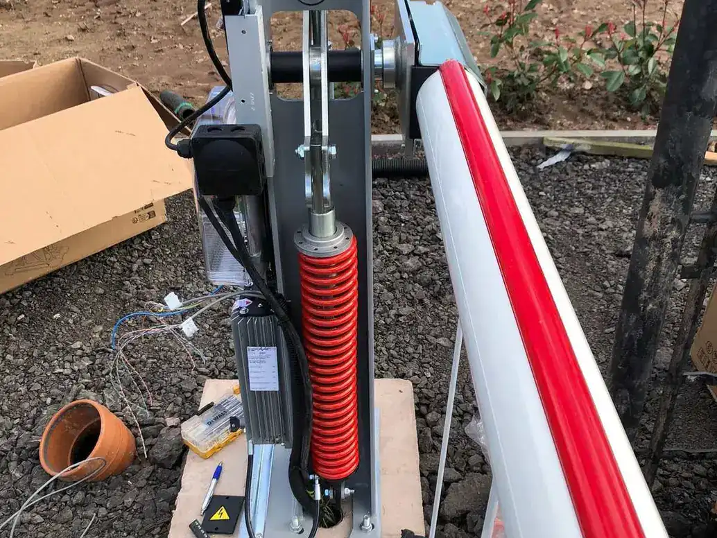 Barrier mechanism and spring on its concrete base during installation, the arm lying beside it