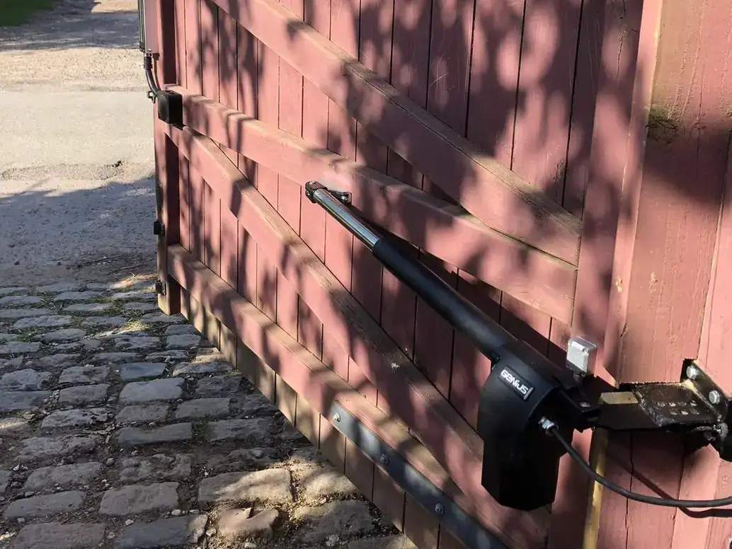 Ram arm fitted to a painted timber driveway gate