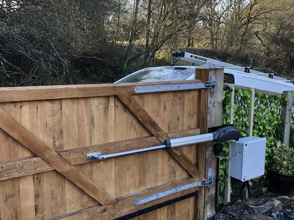 Ram arm and control box fitted to a timber driveway gate