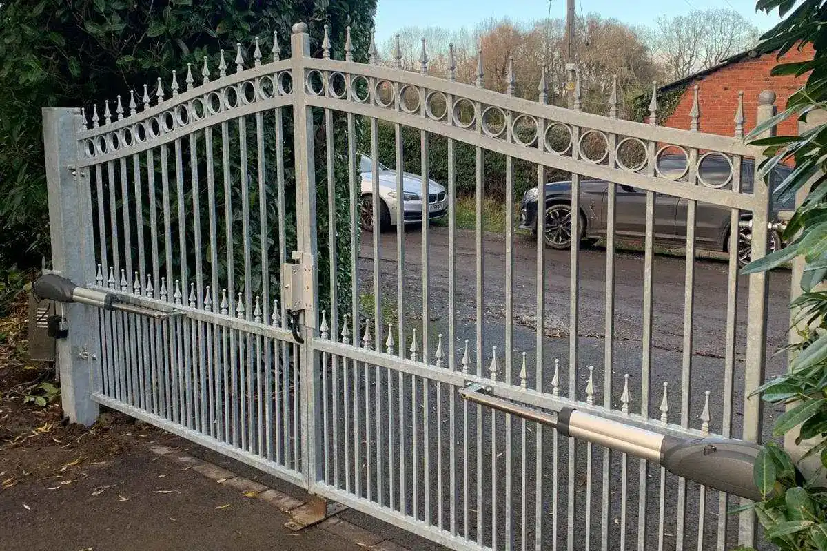 Galvanised steel swing gates with spear finials and a ram arm