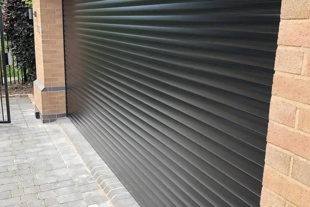Black roller garage door in a brick garage wall