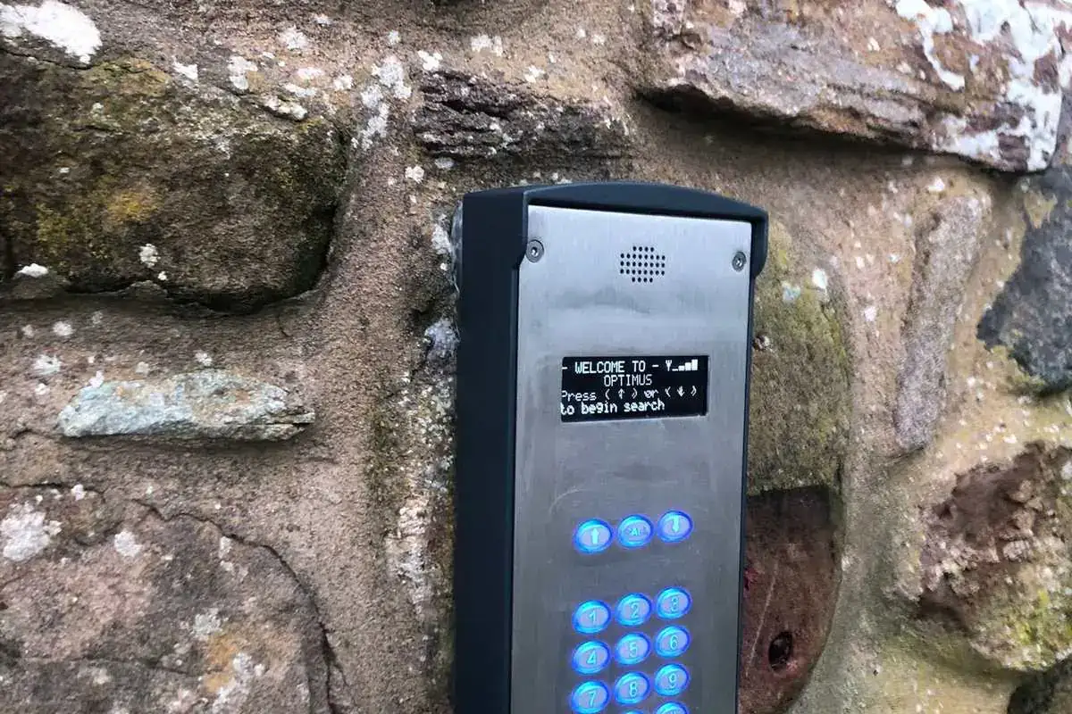 Intercom with a keypad and display on a stone wall