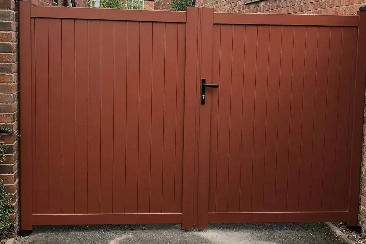 Red-brown aluminium side gates between two brick houses