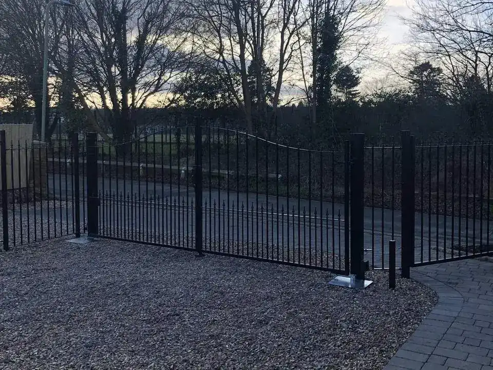 Black railings and a matching pair of gates around a gravel forecourt