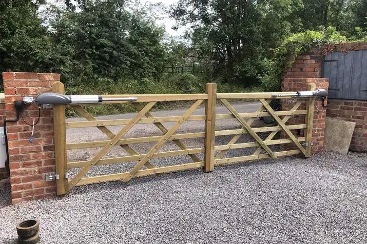 Timber field gates with on-gate motors between brick piers on a gravel drive, Wrockwardine