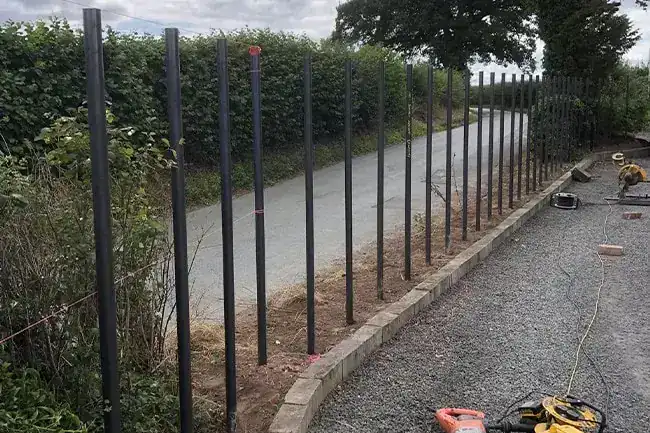 Steel fence posts set along both sides of a lane before the bars go in