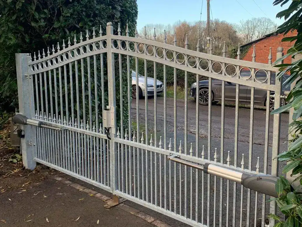 Silver-grey powder-coated iron gates with spear finials and a ram arm